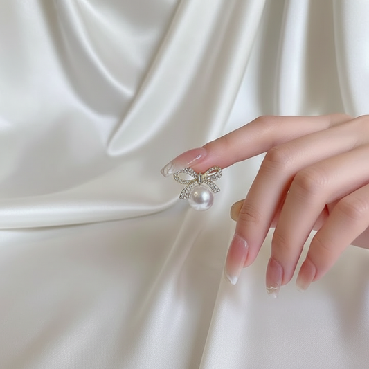 Pearl bow earrings lifestyle shot on white silk